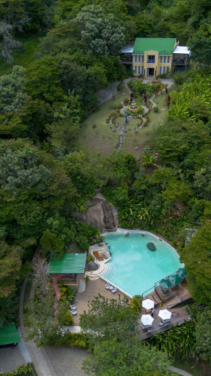 Vista aérea completa de Ancestral Glamping, casa principal, piscina y cascada